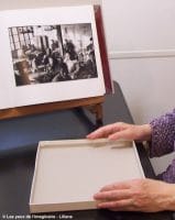 Liliane est non voyante. Elle suit le cours Écouter les photographies. D'abord toucher les quatres bords de la boîte. Ce sont les quatre premières du bord du cadre.